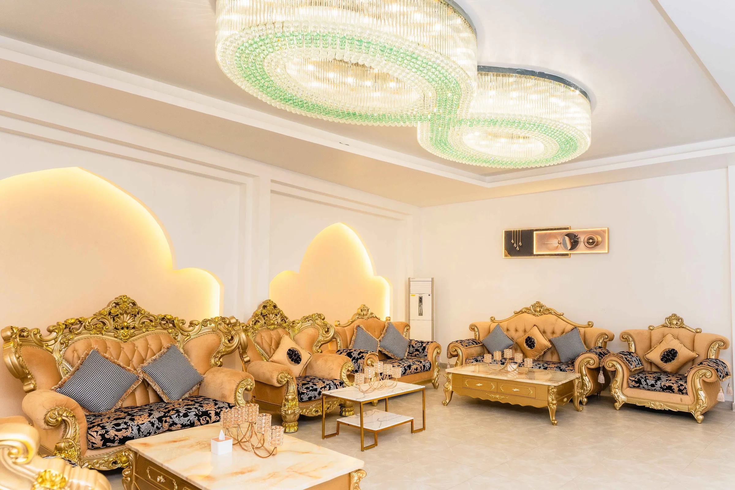 The VIP lounge, furnished with gilded baroque sofas beneath tiered green crystal chandeliers.