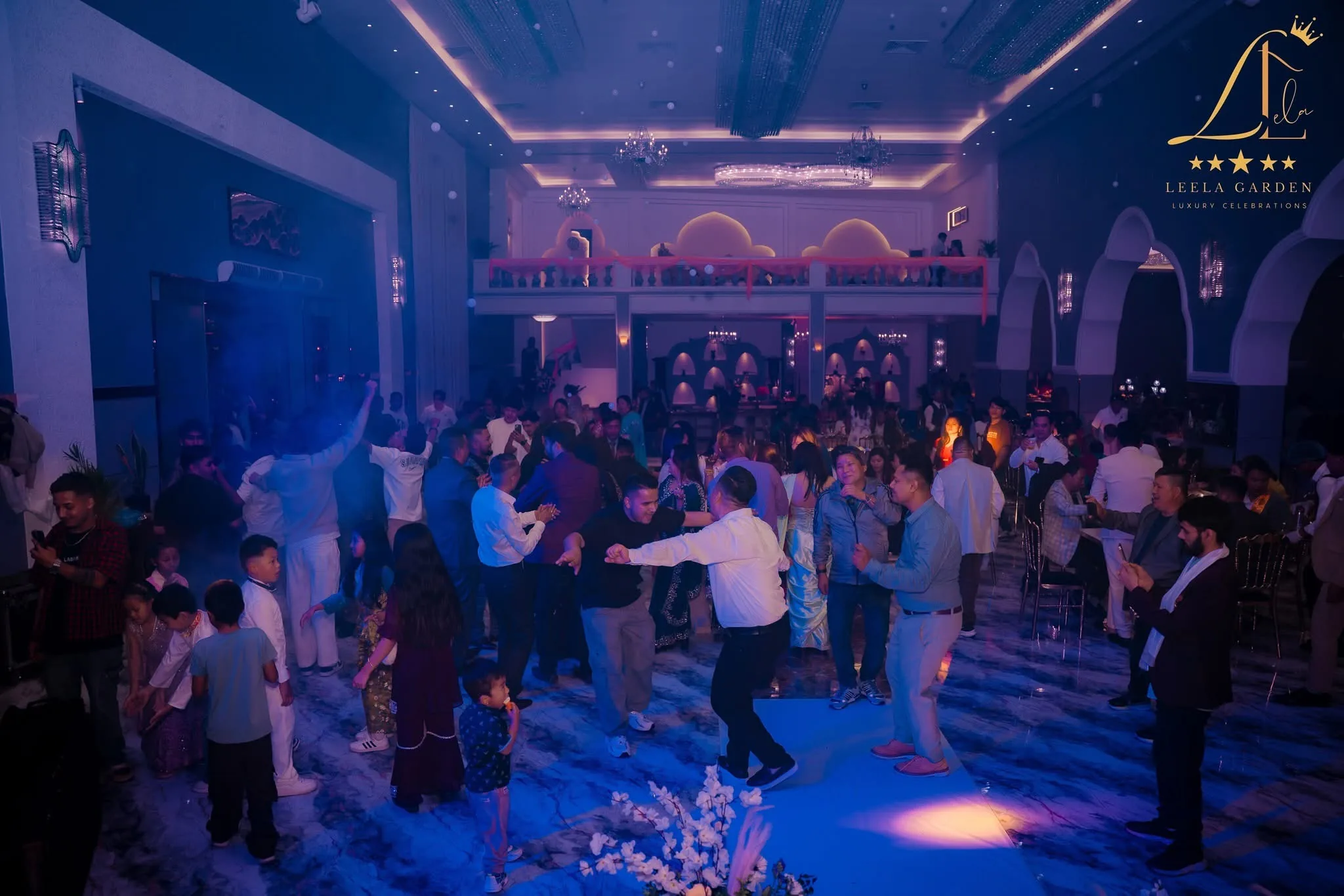 A crowded dance floor in blue light, haze drifting through the beams.