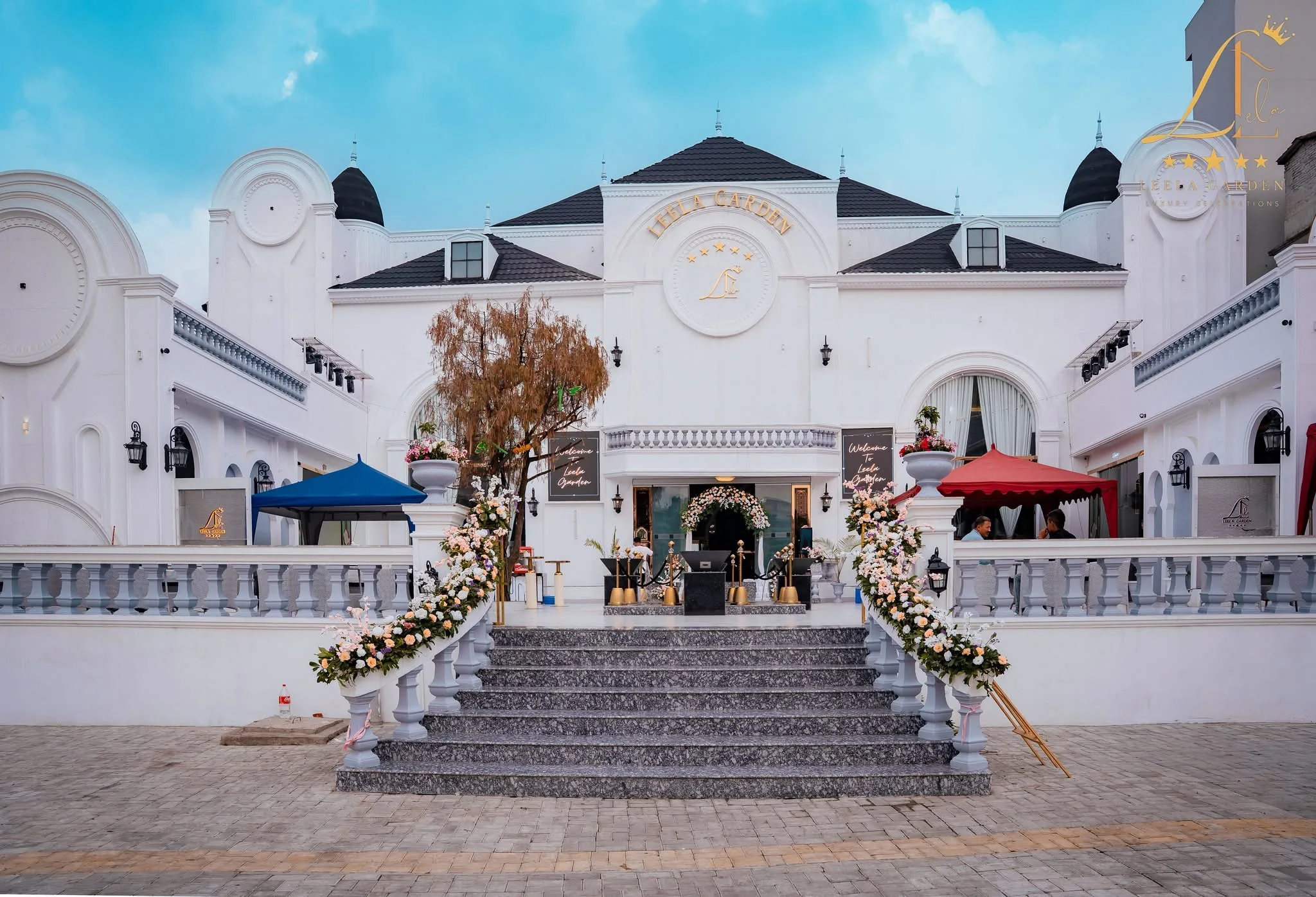The grand balustraded stair sweeping up to the entrance, the crested white facade above it.
