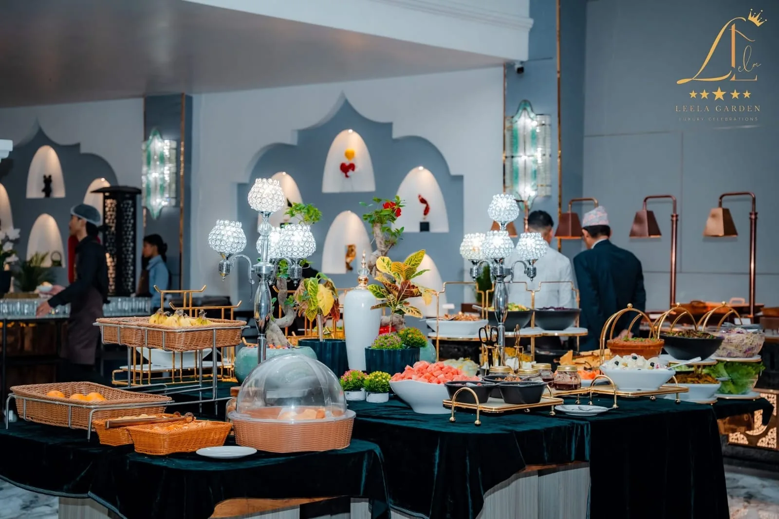 Chefs and service staff at the buffet stations during an event, brass lamps lighting the chafing dishes.